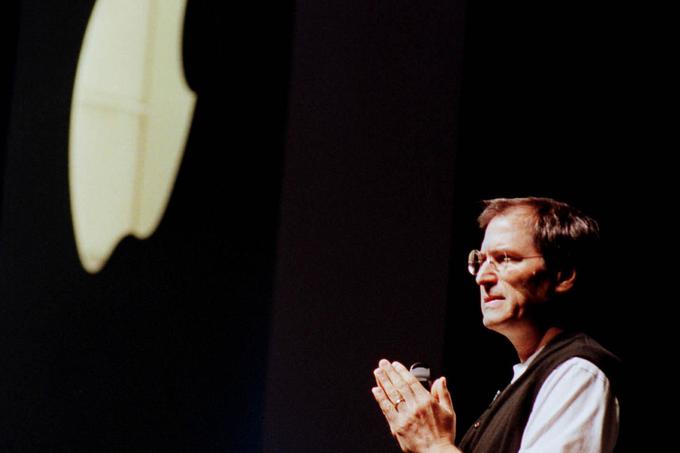 Apple je bil ob ponovnem prihodu Steva Jobsa na vodstveni položaj praktično na robu bankrota. Na fotografiji Steve Jobs avgusta 1997 prisotnim na računalniškem sejmu Macworld Expo pojasnjuje, da je pravkar sprejel 150 milijonov dolarjev vredno finančno injekcijo Microsofta, ki je močno vplivala na rešitev podjetja pred propadom.  | Foto: Reuters