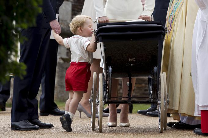 Mali George v kratkih hlačah vpadljive rdeče barve na krstu svoje sestre. | Foto: Reuters