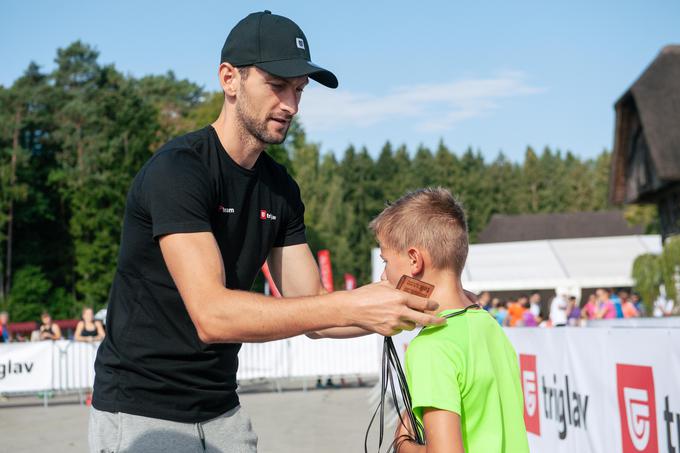 Biatlonec Jakov Fak podeljuje kolajne najmlajšim tekačem. | Foto: Mediaspeed