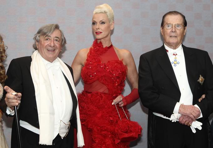 Leta 2012 je Lugner na ples prišel v spremstvu visokorasle Danke Brigitte Nielsen in nekdanjega Jamesa Bonda Rogerja Moora. | Foto: Reuters