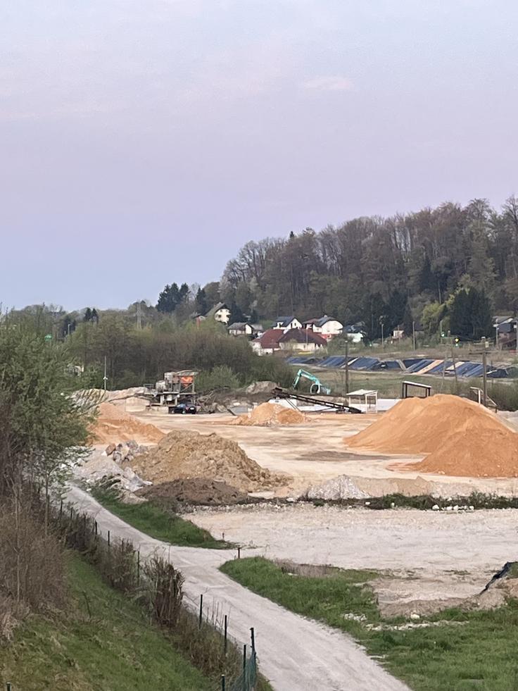 Deponija le nekaj sto metrov od strnjenega naselja v Lukovici. V ozadju hiše krajanov, ki so vsak dan izpostavljeni hrupu in onesnaženju. Kako je mogoče, da občina to dopušča – kljub opozorilom, pritožbam in očitnim kršitvam prostorskih aktov? | Foto: Civilna iniciativa Lukovica