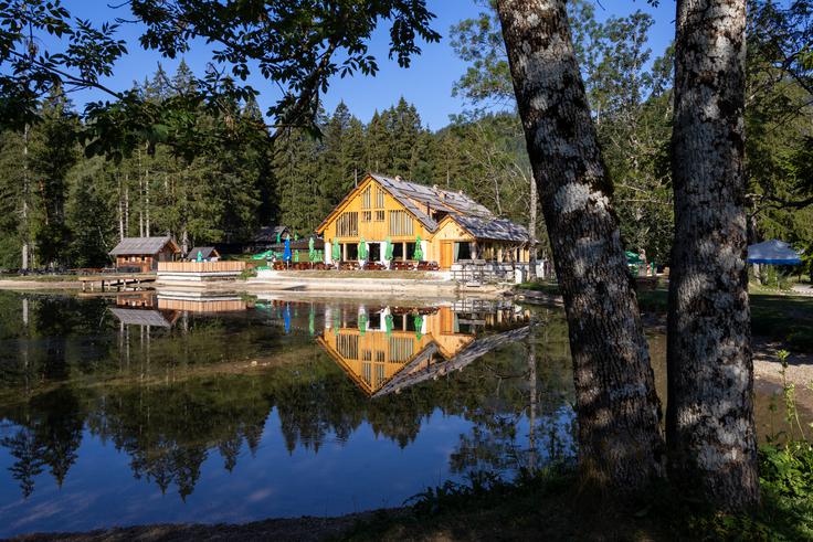 Gostišče pri Planšarskem jezeru so lani podrli in postavili novega, lesenega, da res sodi v to okolje. Samo jezero je srce občine, pa čeprav je umetno, nastalo pred 60 leti. Ledeniško jezero, po katerem je kraj dobil ime, je po potresu odteklo že pred stoletji. | Foto: Matej Podgoršek