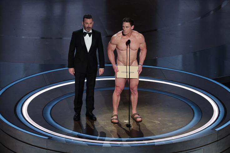 Voditelj Jimmy Kimmel z golim Johnom Ceno, ki je podelil oskarja za najboljšo kostumografijo. | Foto: Reuters