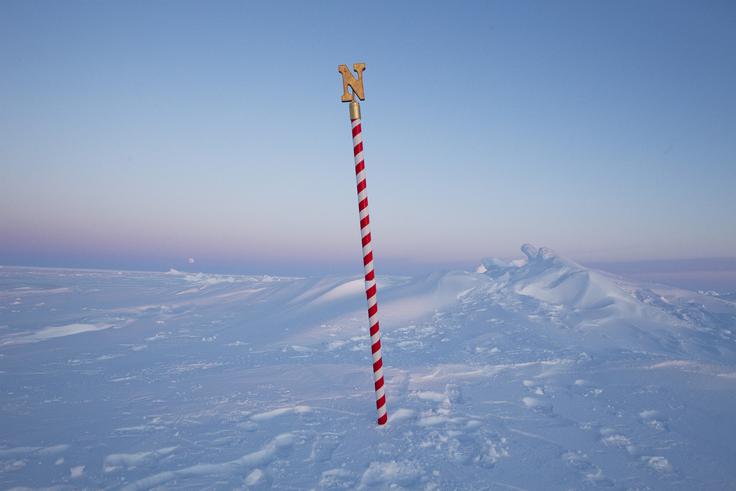 V ozadju znaka za severni pol vzhaja luna. | Foto: Reuters