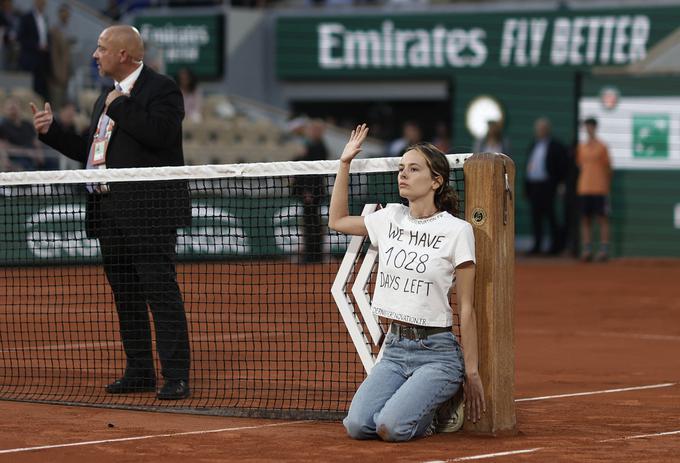 Drugi polfinale je bil za 15 minut prekinjen zaradi ženske, ki je skočila na igrišče in se z vezico privezala na mrežo. Na majici je imela napis: Ostalo nam je že 1028 dni. | Foto: Reuters
