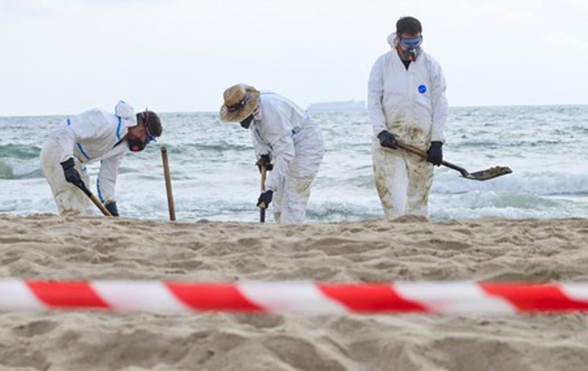Plaža Valencia | Tehniki v belih zaščitnih oblekah so z lopatami odstranjevali oljne madeže. | Foto Profimedia