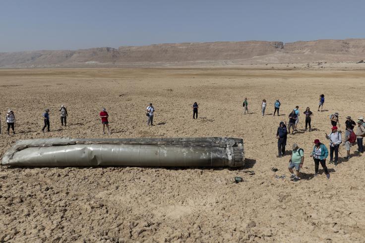 Skupina ljudi si v Izraelu ob Mrtvem morju ogleduje ostanke sestreljene iranske balistične rakete, ki so jo Iranci na Izrael izstrelili aprila letos. | Foto: Guliverimage