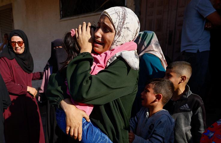 Ženska med pogrebom Palestincev ubitih v Gazi objema svojega otroka.  | Foto: Reuters