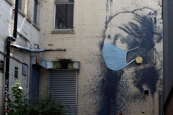 Banksy deklica | Tudi Banksyjevo dekle te dni nosi masko. | Foto Reuters