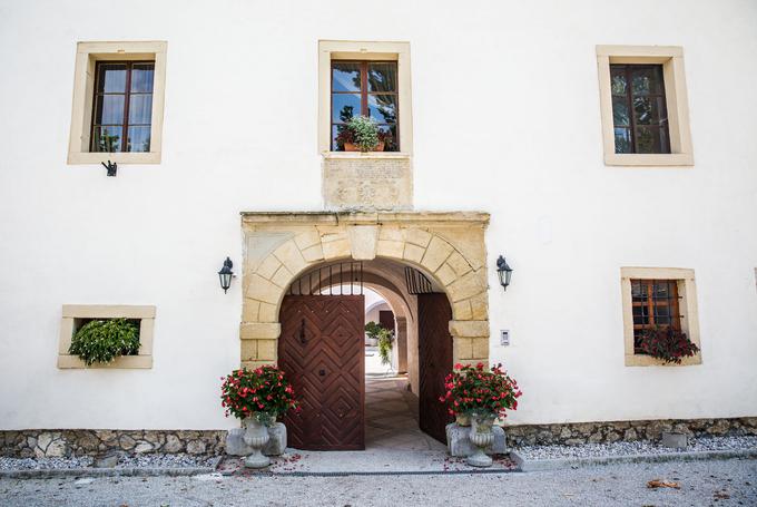Vhod v grad Tuštanj, pred katerim stoji tudi 350-letna platana. Objekt so zgradili leta 1490, o čemer pričajo grbi nad vhodnim portalom gradu.  | Foto: Vid Ponikvar