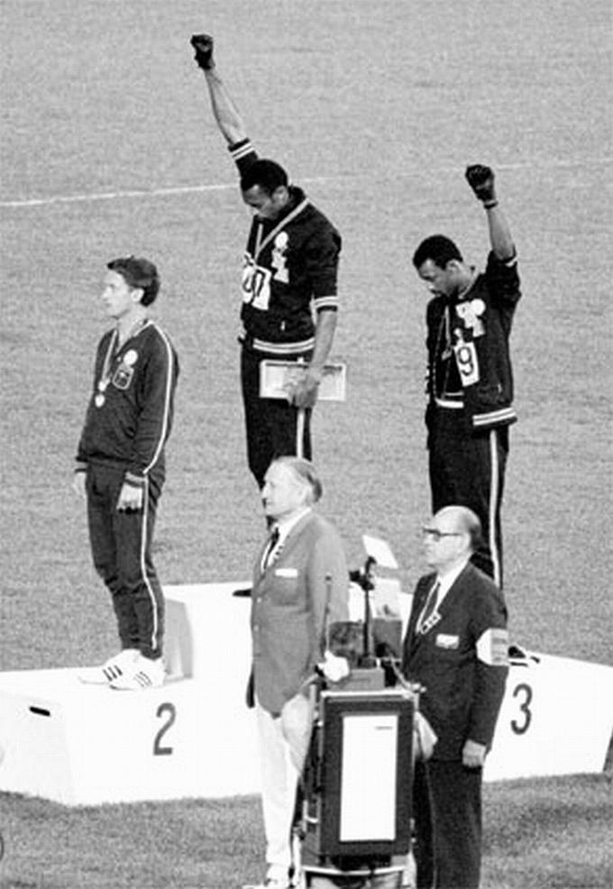 Američana Tommie Smith in John Carlos sta na zmagovalni oder v teku na 200 metrov prikorakala brez čevljev, obuta le v črne nogavice, ki so predstavljale revščino temnopoltih ljudi. Smith je imel okoli vratu ovit črn šal, ki je predstavljal črnski ponos, Carlos pa je imel odpet zgornji del trenirke v znak solidarnosti z delavskim razredom v ZDA in ogrlico okoli vratu, ki je po njegovih besedah simbolizirala vse, ki so bili linčani, ubiti, obešeni in vrženi v morje med prevozom iz Afrike v ZDA v času trgovanja s sužnji, ne da bi kdo za njih molil. | Foto: Guliverimage/Vladimir Fedorenko