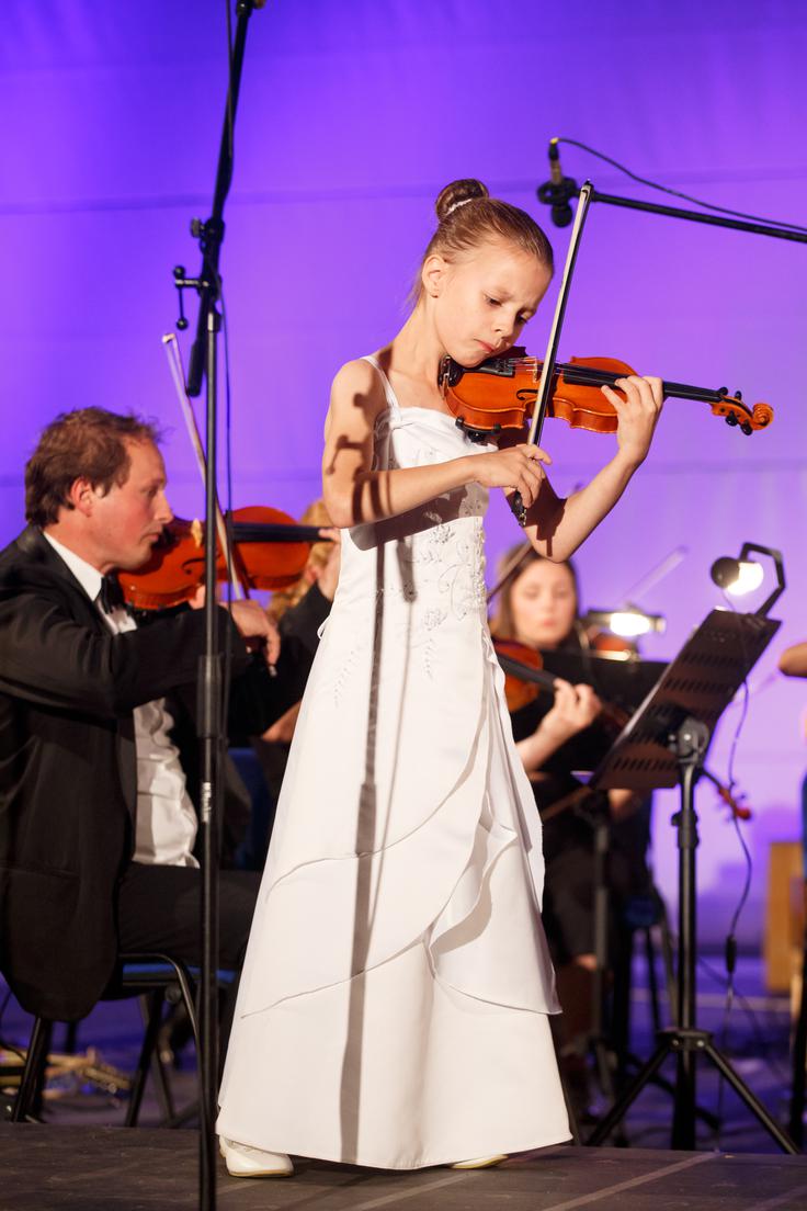 V zelo lepem spominu mi je ostal moj prvi koncert, ki sem ga odigrala pri osmih letih v Logatcu. Prvi koncert je vedno nekaj posebnega in lepega, igrala pa sem z orkestrom svojega očeta (na fotografiji v ozadju). | Foto: arhiv orkestra Cantabile