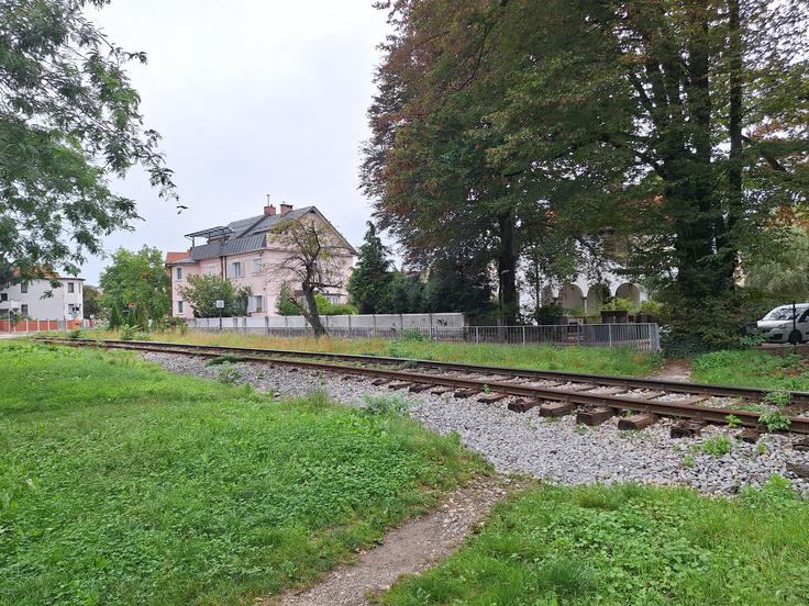 Nezakonit prehod čez železniške tire, ki predstavlja smrtno nevarnost, in le okoli 100 metrov naprej zavarovan nivojski prehod na Povšetovi ulici.  | Foto: Peter Pahor