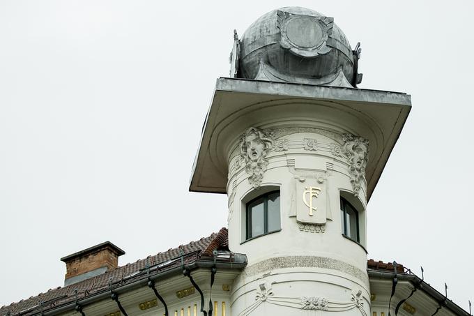 Ena od posebnosti hiše je vogalni stolpič s kvadratnim zaključkom in kroglo, ki ga pod vrhom krasijo ženski maski in zlati inicialki investitorja stavbe. | Foto: Ana Kovač