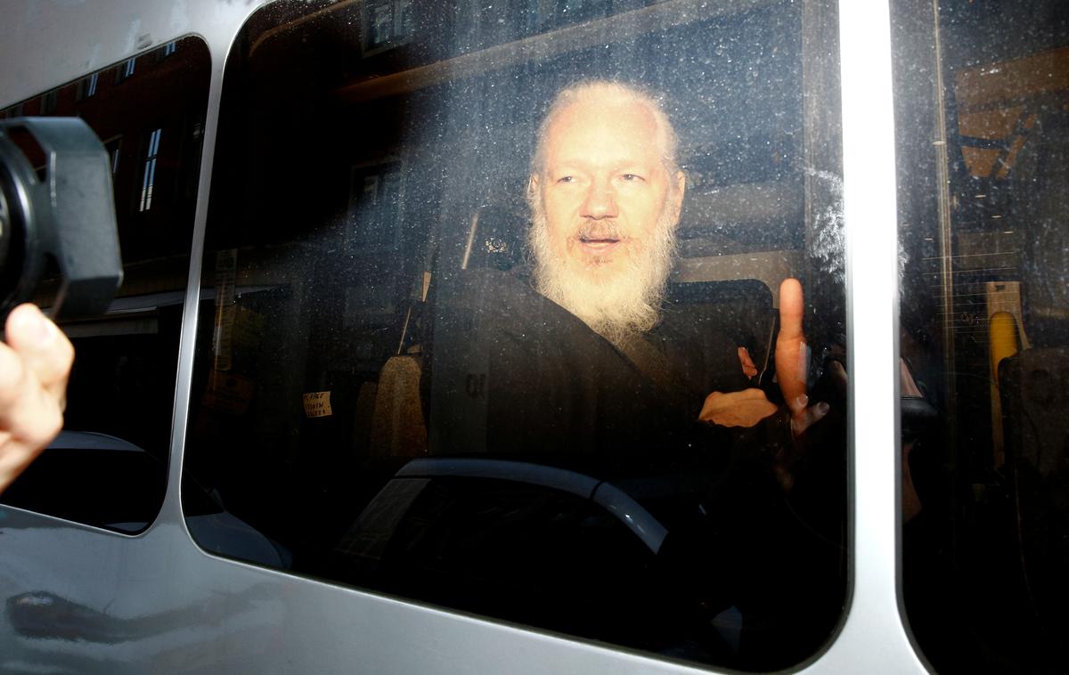Julian Assange | Julian Assange v policijskem vozilu med prevozom na sodišče. | Foto Reuters