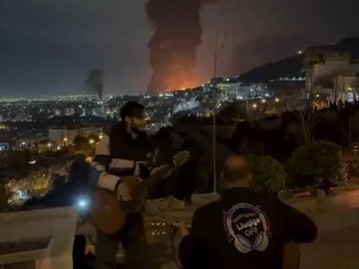 Medtem ko padajo bombe, oni igrajo na kitaro in pojejo