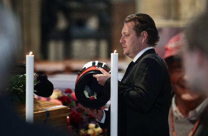 Krstno s posmrtnimi ostanki Laude krasi njegova dirkaška čelada, ki jo na krsto polaga Laudov sin Lukas. | Foto: Reuters