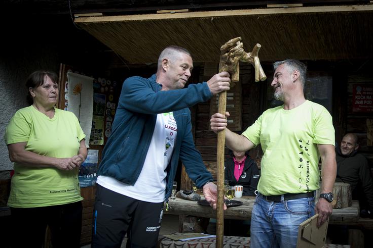 Pod Ojstrico sta prišla tudi takratna oskrbnika Valvasorjevega doma Aleš Štefe in Petra Bratuša, ki sta Novaku prinesla spominsko darilo, lično oblikovano pohodno palico. | Foto: Ana Kovač