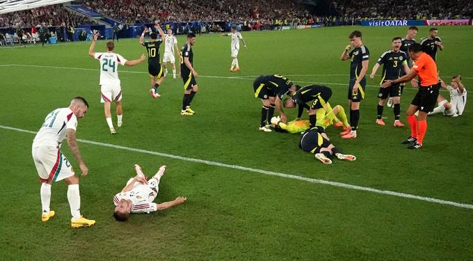 Madžarski nogometaš Barnabas Varga si je med trkom z vratarjem Škotske poškodoval glavo.  | Foto: Reuters