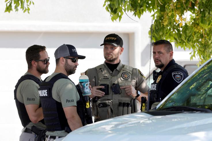 Policisti pred hišo, v kateri naj bi živel Tyler Robinson. | Foto: Reuters