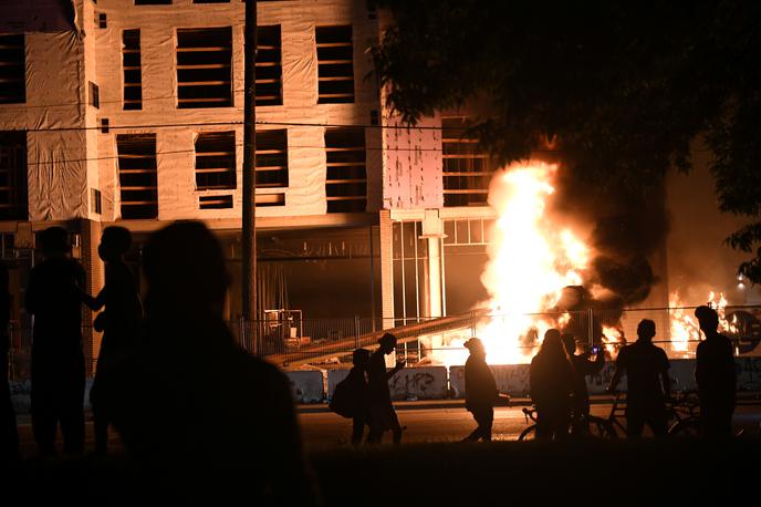 Policija v Minneapolisu | Protestniki v Minneapolisu so vdrli v policijsko postajo, iz katere so policisti pobegnili, in jo zažgali. Razgrajači so zažigali tudi druge zgradbe in ropali trgovine, iz katerih so odnašali vse od cigaret do plenic in hrane. | Foto Reuters