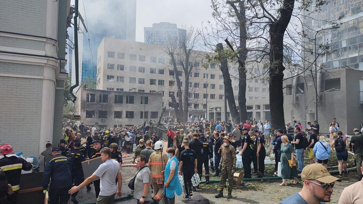 Prizor pred bolnišnico Ohmatdit kmalu po ruskem napadu s križarskimi raketami. Na pomoč otrokom so ob reševalnih službah prihiteli tudi okoliški prebivalci.  | Foto: Reuters