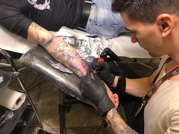 Tetovatorji na dogodku v živo ustvarjajo, obiskovalci pa lahko postopek opazujejo. | Foto: Maša Belak