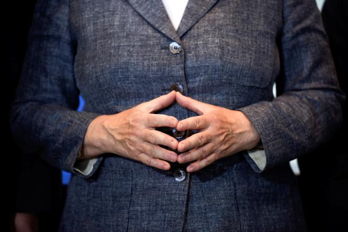Sklenjene roke kanclerke, ki oblikujejo lik romba. | Foto: Reuters