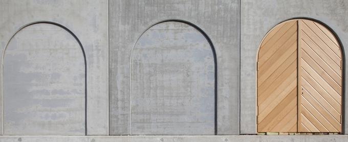 "Nekoliko bolj razgibana je zadnja fasada objekta, ki jo členijo štiri slepe arkade v obliki polkrožno zaključenih niš ter dva stranska vhoda na levem in desnem robu stene z enako obliko loka." | Foto: Kreadom