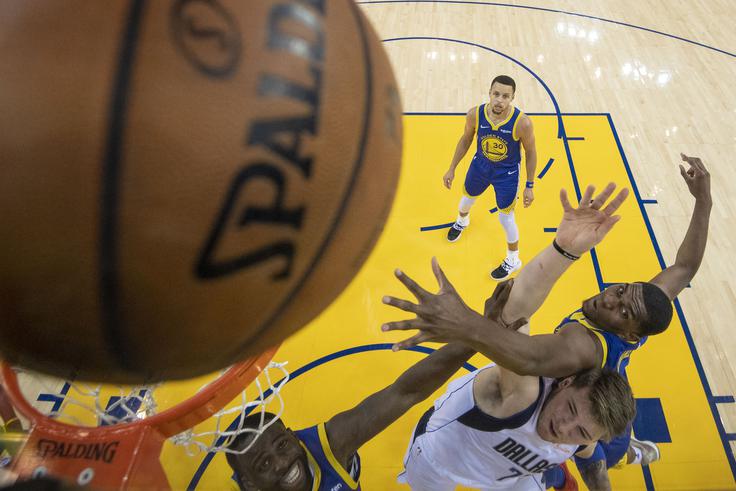 Luka Dončič V dvoboju z Draymondom Greenom (v ozadju Steph Curry). | Foto: Reuters