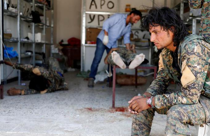 Sirski vojak čaka, kaj se bo zgodilo s kolegom, ki so ga poškodovali borci Islamske države. | Foto: 