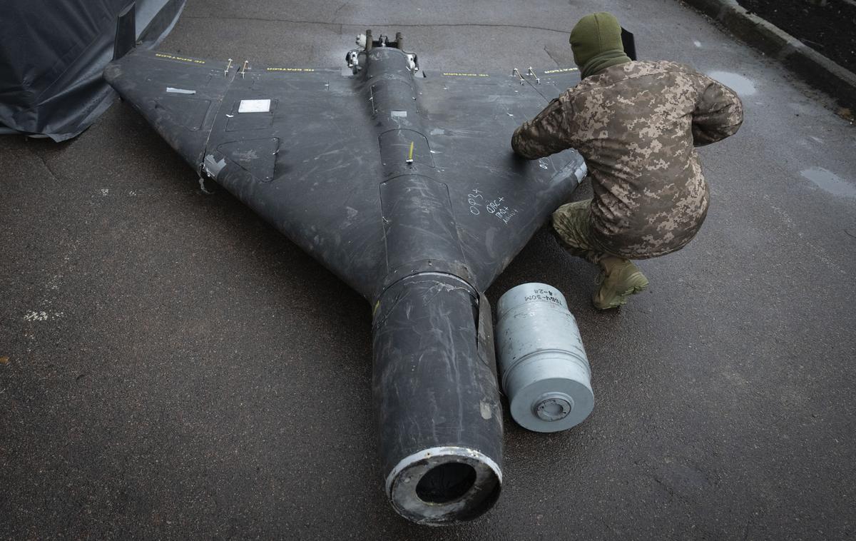 Ukrajinski vojak in ruski dron s termobarično bojno glavo | Rusi naj bi na svoje brezpilotne letalnike dajali tudi termobarične bojne glave. Na fotografiji: ukrajinski častnik novembra letos preiskuje sestreljeni brezpilotni letalnik (gre za iranski dron šahed, ki ga izdeluje tudi Rusija), ki naj bi imel termobarično bojno glavo. | Foto Guliverimage