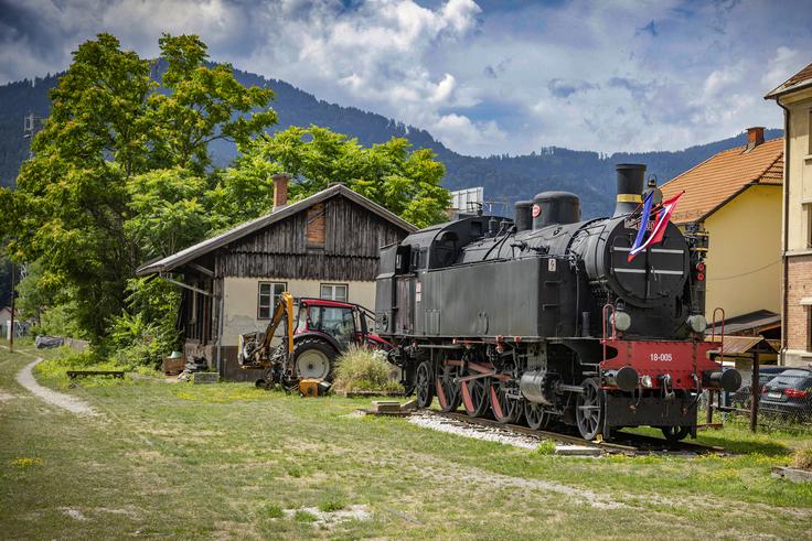 Muzejska parna lokomotiva 18-005, ki so jo postavili v Dravogradu 26. aprila 1985, ob praznovanju 800-letnice Dravograda. Ob odprtju proge 1. junija 1863 je bila v Dravogradu le manjša železniška postaja, večjo pomembnost je dobila po letu 1879 ob odprtju proge Dravograd-Wolfsberg. Postajo so povečali po prvi svetovni vojni, ko je postala obmejna postaja, zaradi česar so jo morali povečati, saj je sedaj tukaj začela delovati obmejna policija, carina, veterinarska služba in špedicijska dejavnost. Postaja Dravograd je predstavljala prometno volišče železniških povezav v koncu 19. in v 20. stoletju vse do ukinitve proge Velenje-Otiški Vrh leta 1969. Tukaj je bilo stičišče železniških tirov iz Maribora, Pliberka oziroma Celovca, Zeltwega in Velenja.  | Foto: Ana Kovač