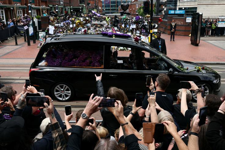 V procesiji so v mrliškem avtu prevažali tudi krsto s pokojnim glasbenikom. | Foto: Reuters
