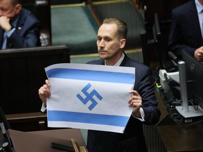 Poljski poslanec v parlamentu razkazoval izraelsko zastavo s svastiko #video