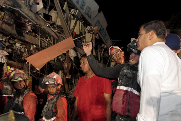 Ekvadorski predsednik Rafael Correa (na fotografiji skupaj z reševalci), ki je v ponedeljek obiskal najhuje prizadeta območja, je v televizijskem nagovoru ljudstvu izrazil bojazen, da bo število smrtnih žrtev potresa še naraslo, saj so mnogi še vedno ujeti v ruševinah. | Foto: Reuters