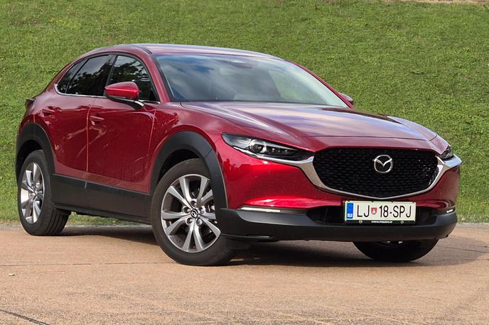 Mazda CX-30 | Rdeča barva je še vedno unikatna, vpadljivo izstopa tudi velika maska, ki povezana s kromom sega do tankih žarometov. Preklop med dolgo in zasenčeno LED svetlobo kajpada deluje avtomatsko. | Foto Aleš Črnivec