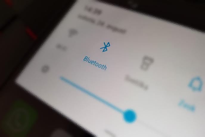 Bluetooth | Bluetooth, ki ga poznamo po modrem simbolu z belo črko B z antenama, je protokol za brezžično povezovanje elektronskih naprav, na primer pametnega telefona s slušalkami. Gre za razmeroma nizkoenergetsko povezavo, zaradi česar bluetooth baterije prenosnih naprav ne obremeni pretirano, a hkrati tudi nima velikega dometa. Povezavo med napravama lahko izgubimo že, če stopimo v drug prostor. | Foto Matic Tomšič