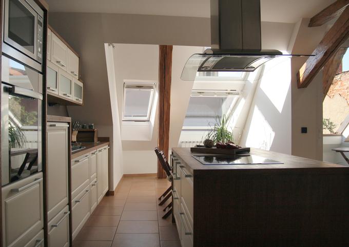 Za obilje naravne svetlobe v osrednjem bivalnem prostoru so zaslužni ustrezno število strešnih oken in steklena drsna vrata, ki ga povezujejo s prostrano strešno teraso. | Foto: 
