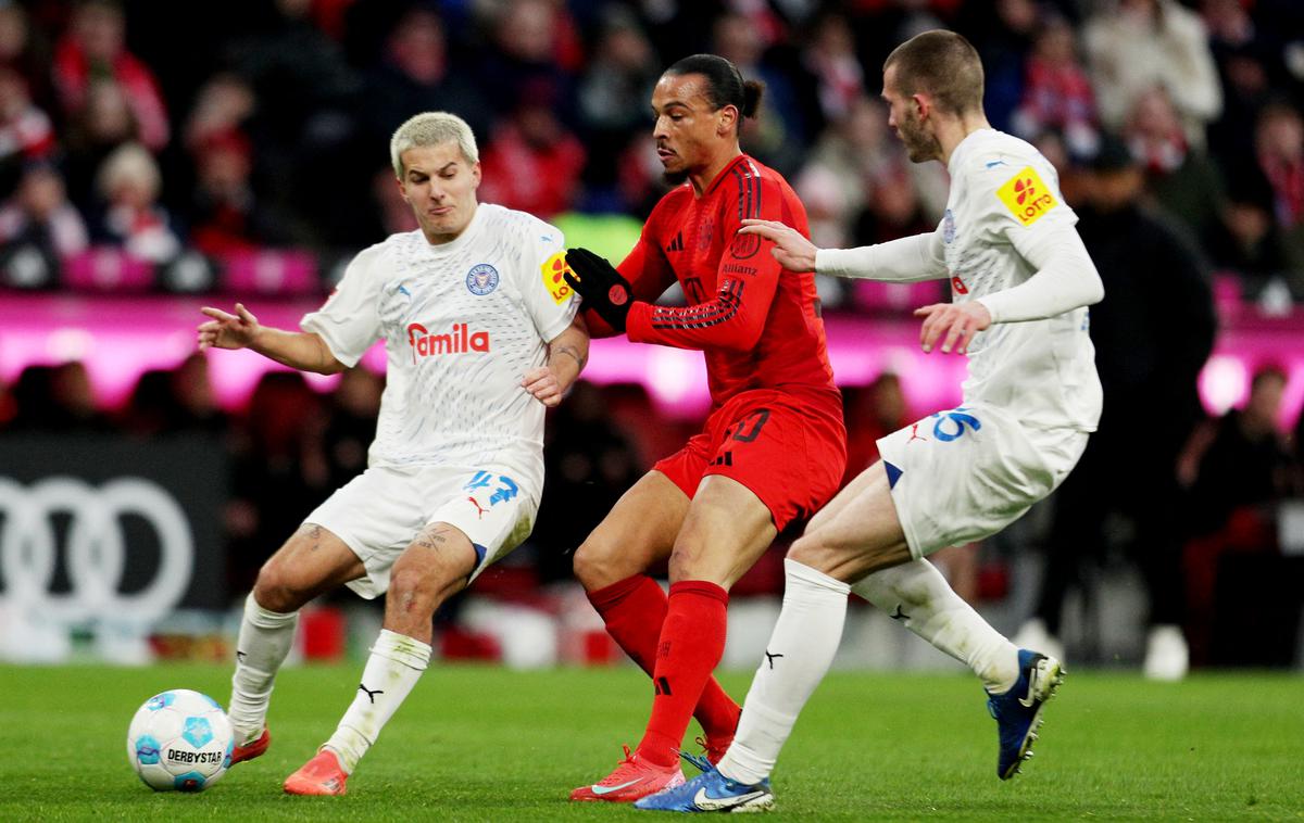 Bayern Kiel Zec | David Zec je v prejšnjem krogu dosegel prvi gol v dresu Kiela, tokrat pa drago prodal kožo Bavarcem. Na sliki (desno) se je tako potegoval za žogo z Leroyjem Sanejem. | Foto Reuters