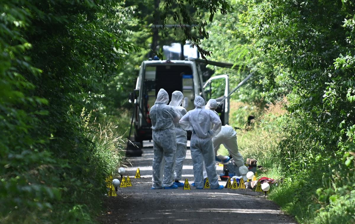 Dorsten - kraj umora | Nemški preiskovalci so, ko so preiskovali truplo ženske na klopi ob gozdni poti, v bližini odkrili še truplo deklice. V nedeljo je k preiskovalcem, ki so na kraju umorov iskali sledi, pristopil 16-letnik iz Ukrajine in priznal umora. Na fotografiji: preiskovalci na gozdni poti v Dorsten-Holsterhausnu. | Foto Guliverimage