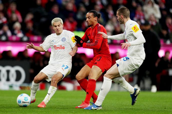 Bayern Kiel Zec | David Zec je v prejšnjem krogu dosegel prvi gol v dresu Kiela, tokrat pa drago prodal kožo Bavarcem. Na sliki (desno) se je tako potegoval za žogo z Leroyjem Sanejem. | Foto Reuters