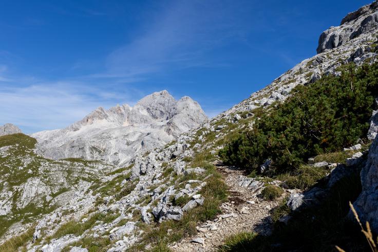 Pol ure pred vrhom se nam levo od Velikega Draškega vrha pokaže Triglav s kočo Planika. | Foto: Matej Podgoršek