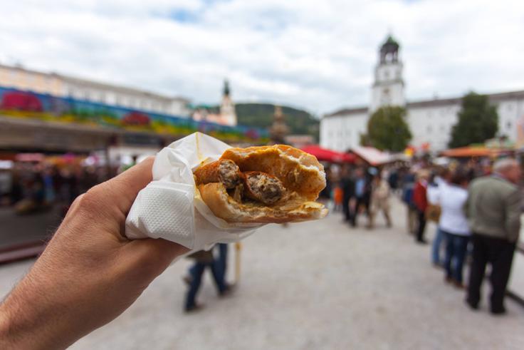 Klobaso bosna prodajajo v Salzburgu na pet različnih načinov priprave: beli kruh z dvema klobasama je prelit s čebulo, peteršiljem, začimbami, gorčico in/ali kečapom. | Foto: Guliverimage
