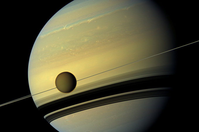 V ospredju Titan, zadaj Saturn. Fotografija je nastala leta 2012, posnela jo je Nasina sonda Cassini. | Foto: NASA