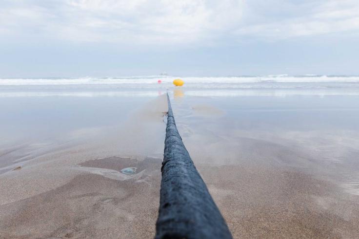 Takole je videti podvodni internetni kabel, ki prečka ocean. Na obali je zavarovan z obilno zaščitno ovojnico, ki preprečuje morebitne poškodbe ali vandalizem, na morskem dnu pa groženj zvečine ni, zato tam potrebe po takšni zaščiti ni. Čeprav povezujejo ves svet, so podmorski internetni kabli pravzaprav precej piškavi, njihov premer meri približno toliko kot vrtna cev.  | Foto: Microsoft