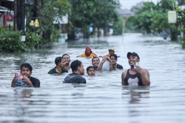 Močno deževje, ki je trajalo več dni, je poplavilo območja na Baliju. Na ulici pa se znajde tudi kakšen piton.  | Foto: Reuters