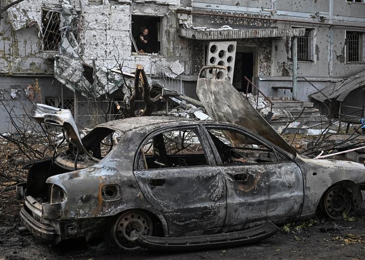 Uničena stanovanjska stavba in zoglenelo vozilo po ruskem zračnem napadu v Zaporožju. | Foto: Reuters