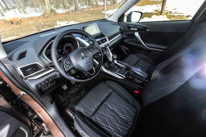 Voznik in sopotnik spredaj lahko izbirata pregledne menije na osrednjem zaslonu ali na dotik ali z drsno ploščico in še s štirimi stikali med sedežema.  | Foto: Gašper Pirman