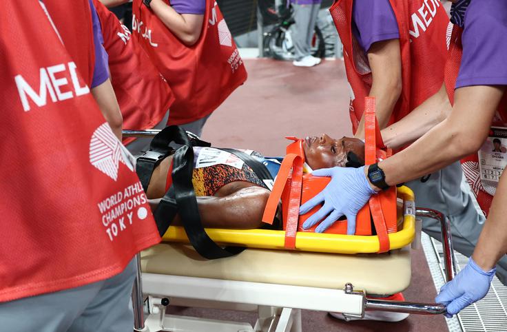 Ugandčanko Peruth Chemutai so s prizorišča odpeljali na nosilih. | Foto: Reuters